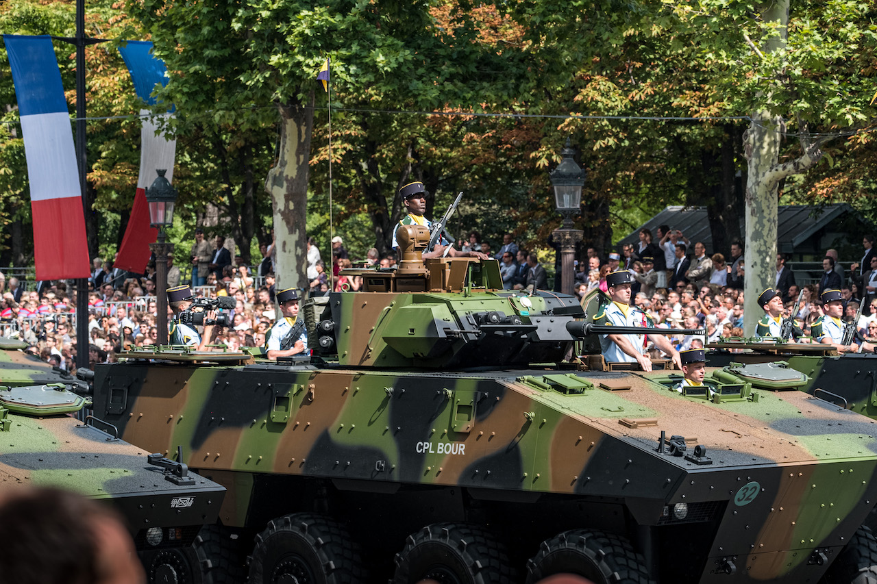 Photo d'un tank vert (et marron, noir) sur les Champs Élysées lors du défilé du 14 juillet