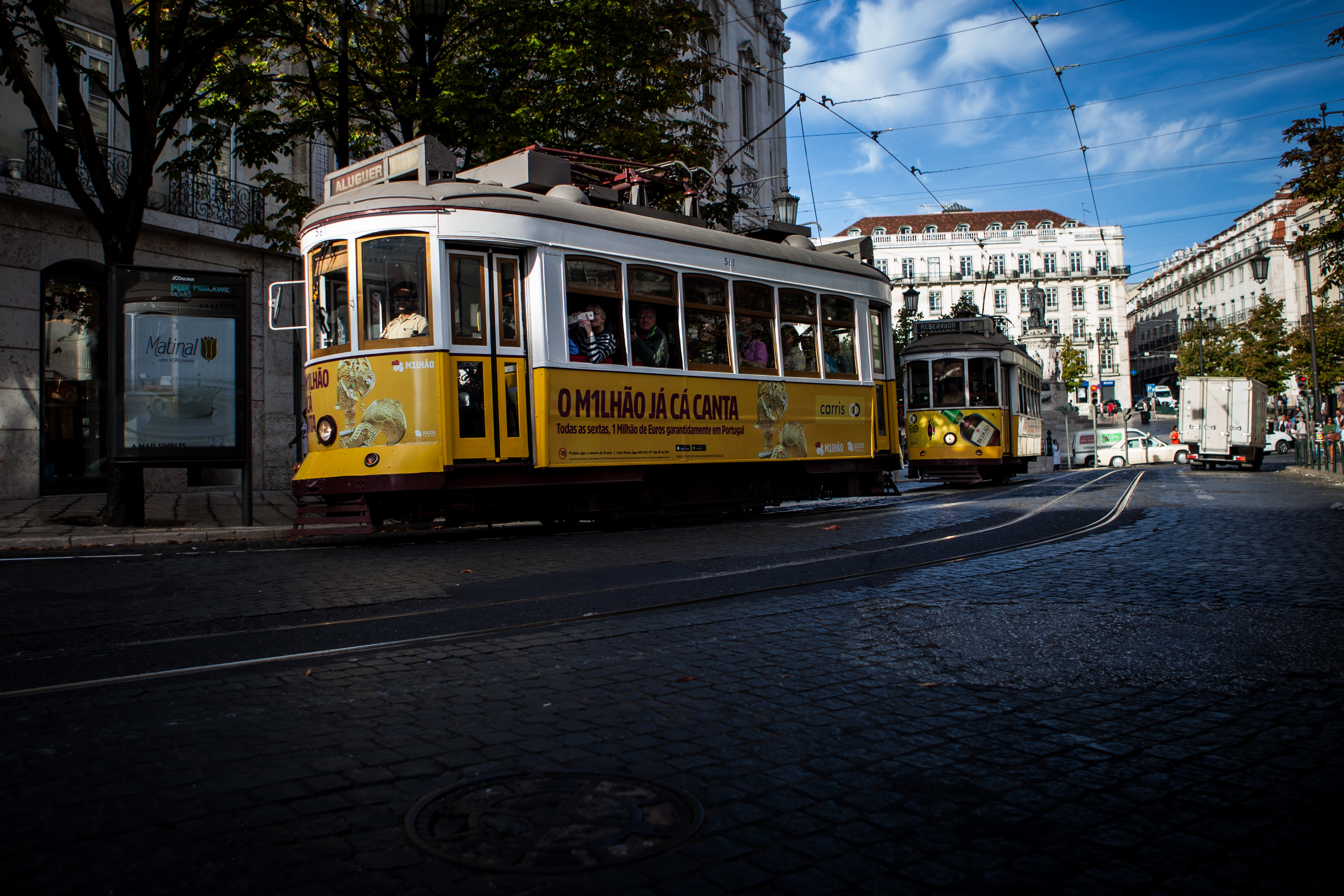 Photo of a nice yellow and white streetcar in a street of Lisbon in Portugal