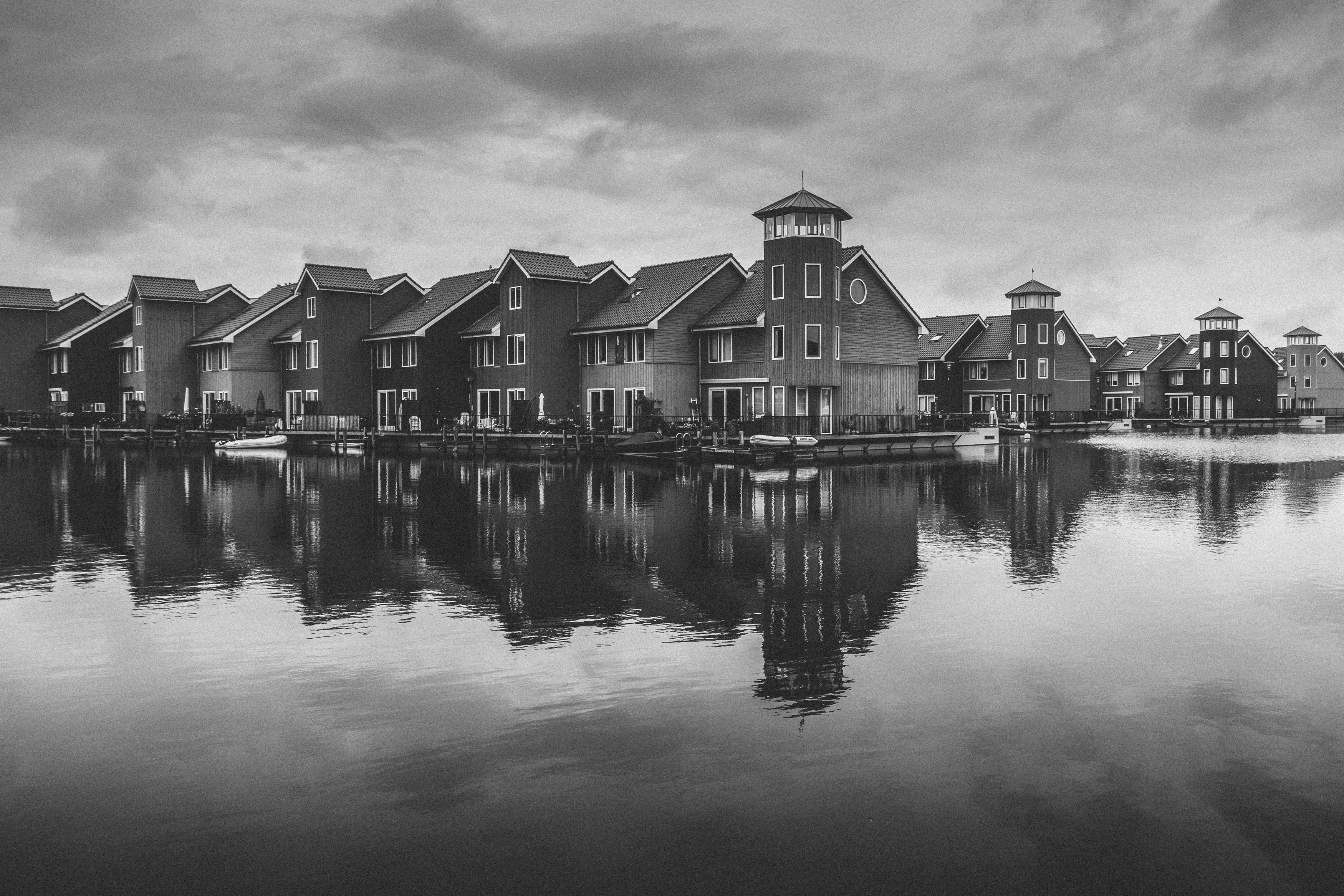 Black and white photo of townhouses on the waterfront, under a cloudy sky